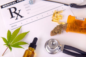 Assorted cannabis products, pills and cbd oil over medical prescription sheet